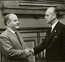 Molotov (vlevo) si potřásá rukou s Ribbentropem (vpravo) po podepsání smlouvy.